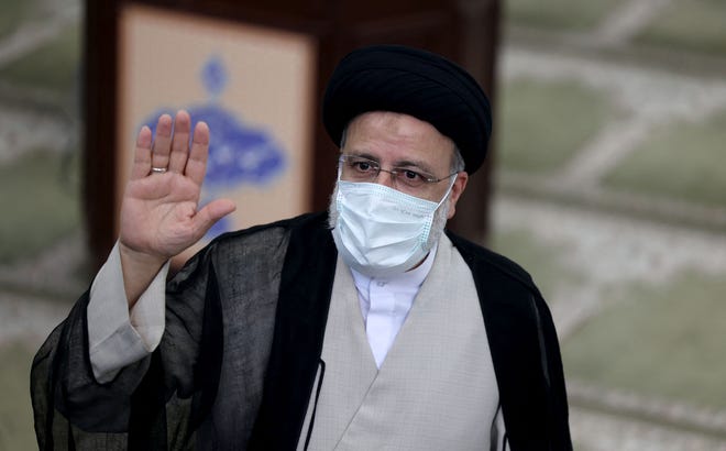Iranian ultraconservative cleric and presidential candidate Ebrahim Raisi waves as he votes at a polling station in the capital Tehran, on June 18, 2021.