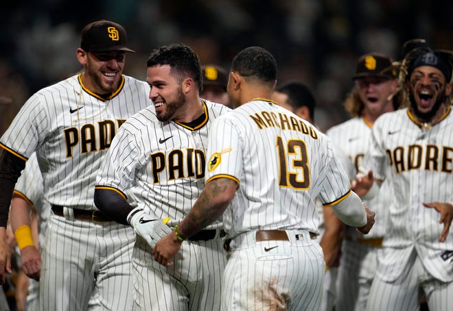 June 17: San Diego Padres catcher Victor Caratini celebrates with teammates after hitting a walk-off home run against the Cincinnati Reds at Petco Park.