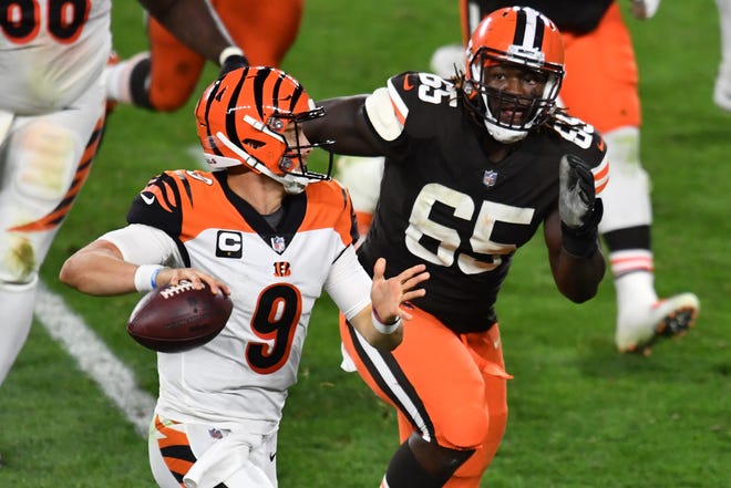 Sep 17, 2020; Cleveland, Ohio, USA; Cleveland Browns defensive tackle Larry Ogunjobi (65) chases Cincinnati Bengals quarterback Joe Burrow (9) during the second half at FirstEnergy Stadium.