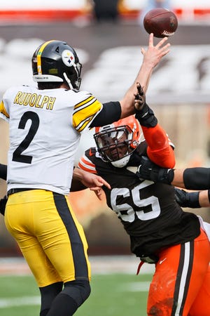 Browns defensive tackle Larry Ogunjobi (65) rushes Steelers quarterback Mason Rudolph (2) during the first half, Sunday, Jan. 3, 2021, in Cleveland. (AP Photo/Ron Schwane)