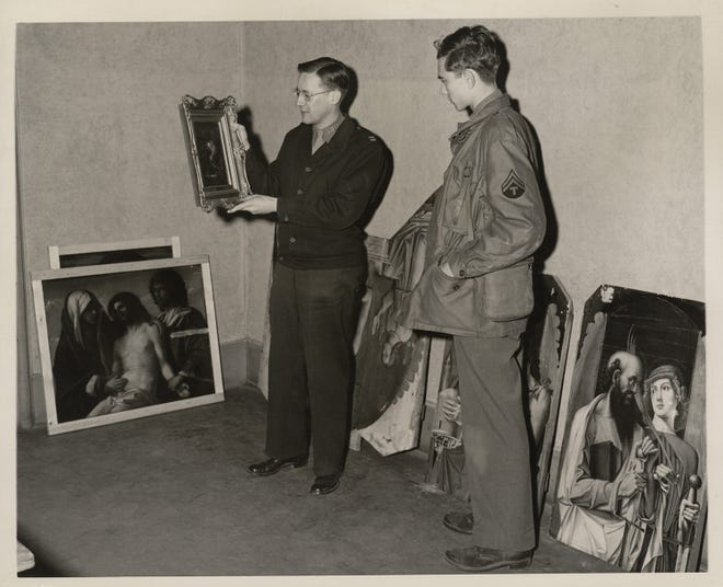 Walter Farmer holding a painting at Wiesbaden Central Collecting Point, Lindsay C. Kenneth Papers, Special Collections, Binghamton University Libraries, Binghamton University, State University of New York.