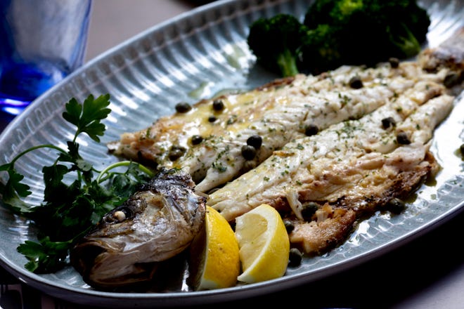 De-Boned Branzino sits on a platter dressed with lemon, olive oil, capers, and house lemon oil, at OKTO Restaurant in Cincinnati on Friday, July 9, 2021. The restaurant is scheduled to open at the end of the month of July. 