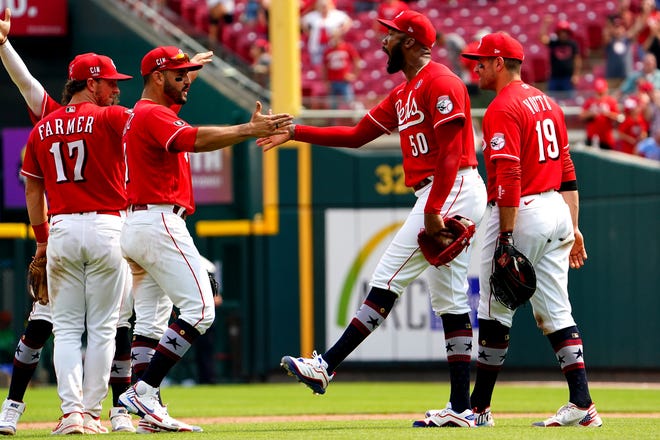 Cincinnati Reds relief pitcher Amir Garrett (50) and Cincinnati Reds third baseman Eugenio Suarez (7) celebrate the 3-2 win against the Chicago Cubs at the conclusion of a baseball game, Sunday, July 4, 2021, at Great American Ball Park in Cincinnati. 