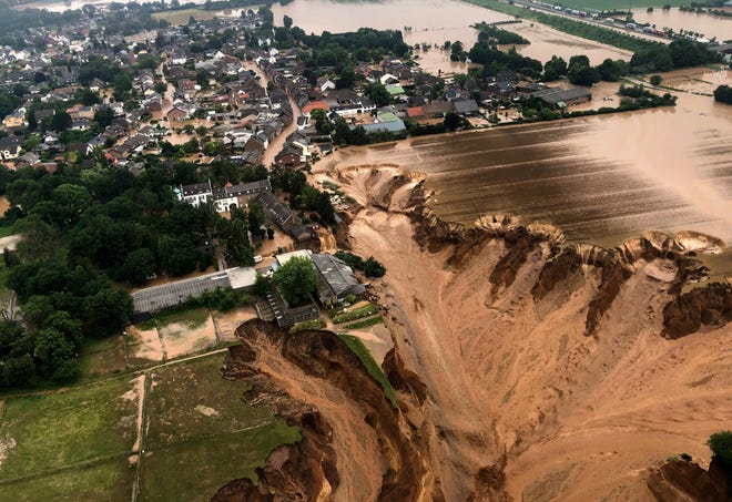 This image provided on Friday, July 16, 2021 by the Cologne district government shows the Blessem district of Erftstadt in Germany. Rescuers were rushing Friday to help people trapped in their homes in the town of Erftstadt, southwest of Cologne. Regional authorities said several people had died after their houses collapsed due to subsidence, and aerial pictures showed what appeared to be a massive sinkhole.