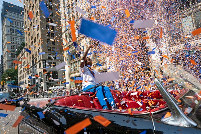 Grand marshal Sandra Lindsay, a health care worker who was the first person in the country to get a COVID-19 vaccine shot, waves to spectators as she leads marchers through the Financial District as confetti falls during a parade honoring essential workers for their efforts in getting New York City through the COVID-19 pandemic, Wednesday, July 7, 2021, in New York.