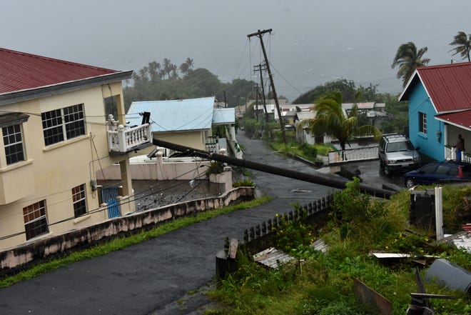 An electrical pole felled by Hurricane Elsa leans on the edge of a residential balcony, in Cedars, St. Vincent, Friday, July 2, 2021. Elsa strengthened into the first hurricane of the Atlantic season on Friday as it blew off roofs and snapped trees in the eastern Caribbean, where officials closed schools, businesses and airports.