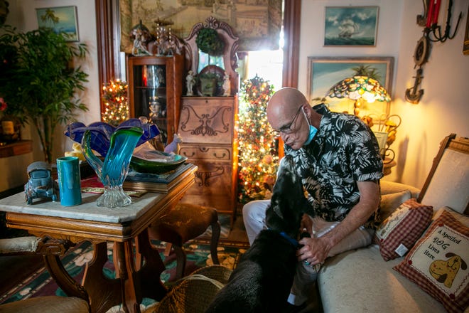 Tim Reed with his dog in their home at Court View Apartments in Downtown. Reed, 61, said he planned to live out his life in the two-bedroom apartment he has lived in for 19 years but is now in the process of being evicted by a developer with other plans.