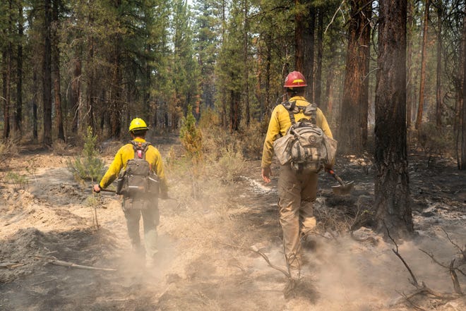 Firefighters Garret Suza, right, and Cameron Taylor, with the Chiloquin Forest Service, search for hot spots on the North East side of the Bootleg Fire, Wednesday, July 14, 2021, near Sprague River, Ore.