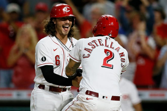 Cincinnati Reds right fielder Nick Castellanos (2) and second baseman Jonathan India (6) celebrate after scoring on Joey Votto's go-ahead two-run double in the sixth inning of the MLB National League game between the Cincinnati Reds and the Chicago Cubs at Great American Ball Park in downtown Cincinnati on Friday, July 2, 2021. An RBI double scoring two runs off the bat of Joey Votto secured the win for the Reds. 