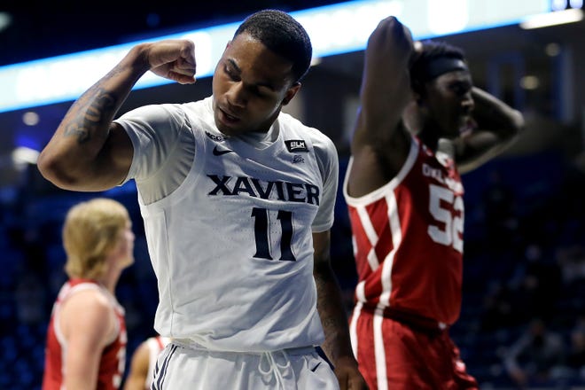 Xavier Musketeers guard Dwon Odom (11) reacts after scoring and drawing a foul from Oklahoma Sooners forward Kur Kuath (52), background, in the first half of a men's NCAA college basketball game, Wednesday, Dec. 9, 2020, at Cintas Center in Cincinnati. 