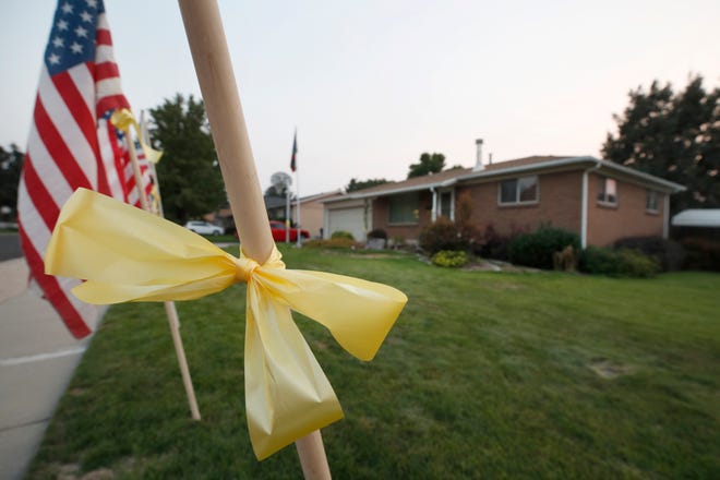 American flags and yellow ribbons line the sidewalk outside the house of Darren Hoover, whose son, Staff Sgt. Taylor Hoover was killed in Afghanistan, on August 27.