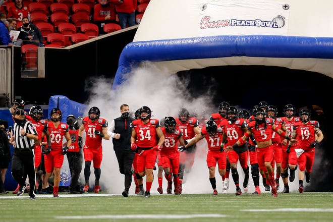 Cincinnati Bearcats head coach Luke Fickell leads his team onto the field for the first quarter of the Chick-fil-a Peach Bowl at Mercedes-Benz Stadium in Atlanta on Friday, Jan. 1, 2021. The Bearcats led 14-10 at halftime. 