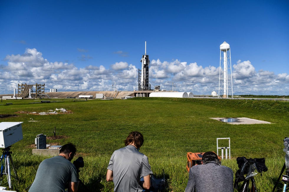 Media crew set up their equipment as the SpaceX Falcon 9 rocket and Crew Dragon is seen in the background sitting on launch Pad 39A at NASAs Kennedy Space Center, as it is prepared for the first completely private mission to fly into orbit in Cape Canaveral, Florida on September 15, 2021.
