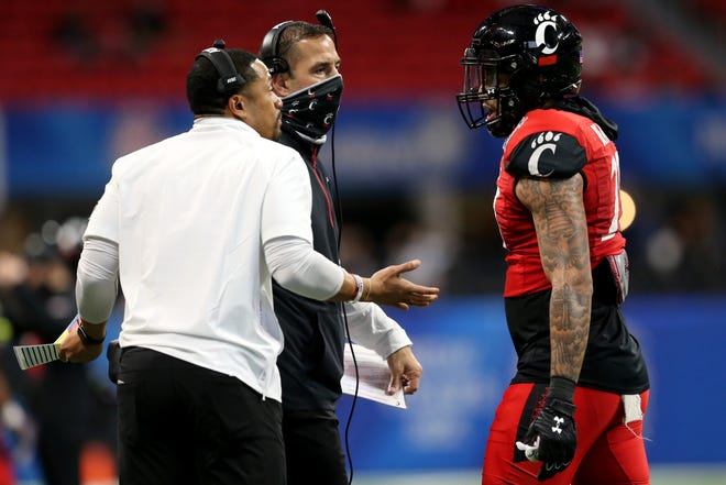 Cincinnati Bearcats defensive coordinator Marcus Freeman, left, and Cincinnati Bearcats head coach Luke Fickell right, talk to Cincinnati Bearcats linebacker Darrian Beavers (27) after a touchdown by Georgia Bulldogs wide receiver George Pickens (1) (not pictured) the second quarter during the Chick-fil-A Peach Bowl, Friday, Jan. 1, 2021, at Mercedes-Benz Stadium in Atlanta, Georgia.