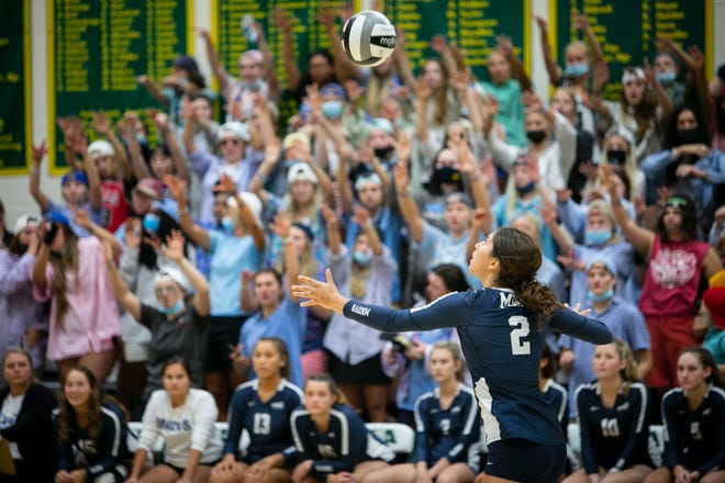 The Mount Notre Dame student section cheers on the varsity volleyball team as senior Carly Hendrickson serves the ball against Ursuline Academy Tuesday, Aug. 31.