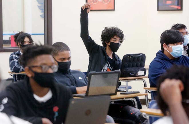 Gradon Smetts, 15, raises his hand to answer a question in his English 10 class at the NIHF STEM High School Wednesday, Aug. 25, 2021 in Akron, Ohio. Masks are required to be worn by students and staff.