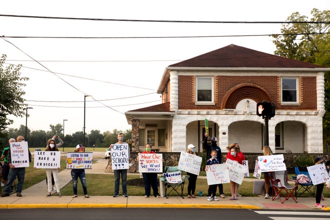 A group of parents and students protest the Talawanda School District for not having in-person classes outside the school district board office at 131 W. Chestnut St. in Oxford, Ohio, on Wednesday, Sept. 16, 2020.