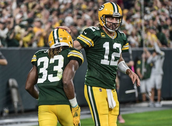 Green Bay Packers running back Aaron Jones celebrates with quarterback Aaron Rodgers after scoring a touchdown in the first quarter against the Detroit Lions at Lambeau Field.