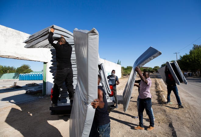 Haitian migrants unload cots at a new designated space for the migrants to stay while they resolve their migratory status in Ciudad Acuña.