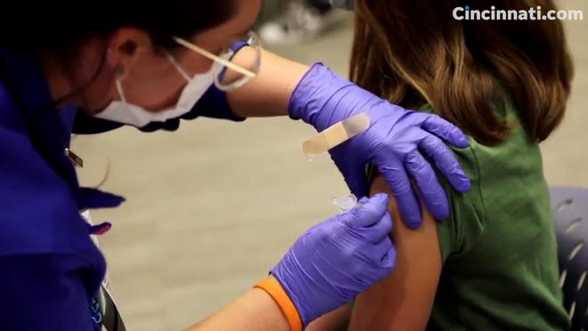 A Cincinnati Children's Hospital Medical Center nurse vaccinates a teenager.
