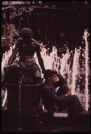 At the Tyler Davidson Fountain, in Fountain Square Downtown Cincinnati's Popular Public Plaza, a Young Man Listens to the Radio with One Ear, Play of the Water with the Other 08/1973