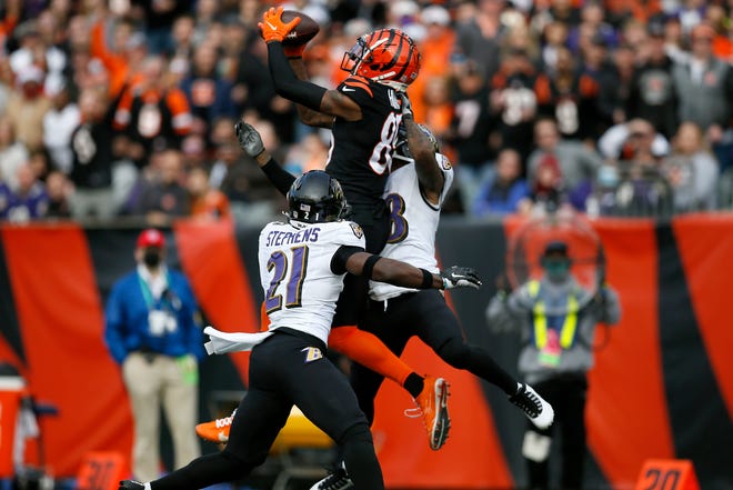 Cincinnati Bengals wide receiver Tee Higgins (85) makes a leaping catch for a first down over Baltimore Ravens free safety Brandon Stephens (21) in the second quarter of the NFL Week 16 game between the Cincinnati Bengals and the Baltimore Ravens at Paul Brown Stadium in downtown Cincinnati on Sunday, Dec. 26, 2021. The Bengals led 31-14 at halftime. 