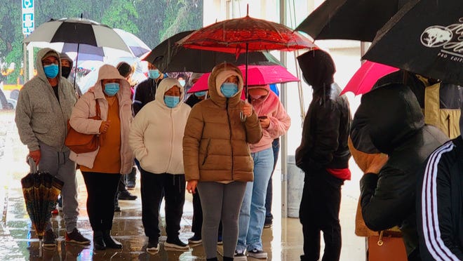 People wear face mask as they stand in line for a free COVID-19 test outside the Lincoln Park Recreation Center in Los Angeles on Thursday, Dec. 30, 2021.