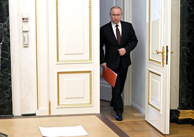 Russian President Vladimir Putin enters a hall to chair a Security Council meeting in Moscow, Russia, Friday, Feb. 25, 2022.