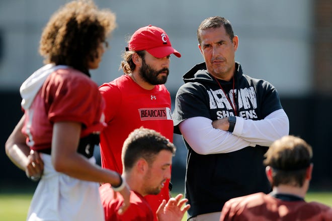 Bearcats head coach Luke Fickell checks in with the quarterbacks during the first day of preseason training camp at the University of Cincinnati’s Sheakley Athletic Complex in Cincinnati on Wednesday, Aug. 3, 2022.